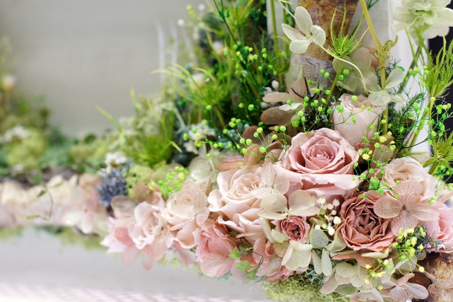 淡いピンクのバラとグリーンをあしらった、やさしい雰囲気のフラワーアレンジメント