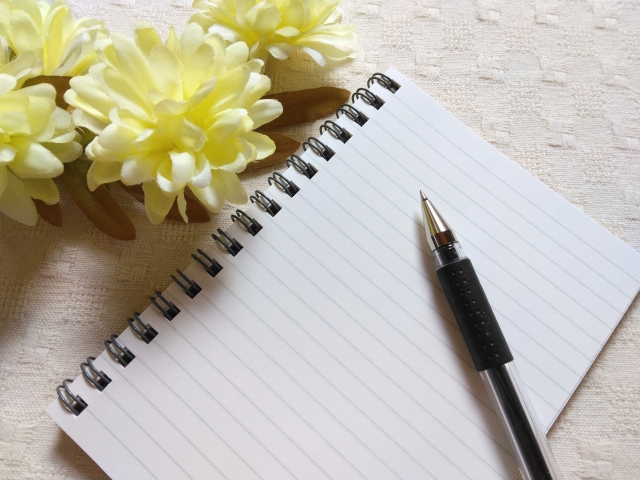 お花教室の選び方をメモすることを想起させるメモ帳とボールペンの画像
