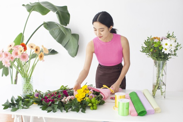 フラワーアレンジメント用のお花を選ぶ女性