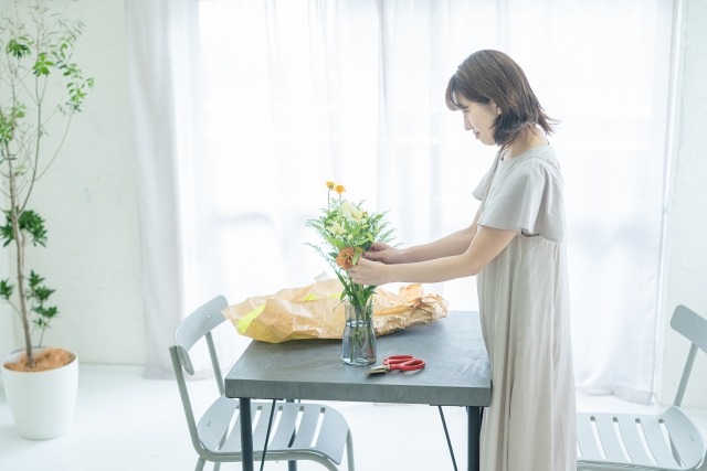 自宅でフラワーアレンジメントをお行う女性