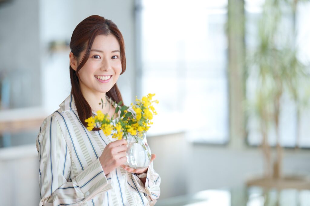 お花を手に持ち笑顔を見せる女性