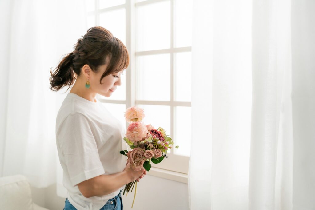 手に持つお花を見つめる女性